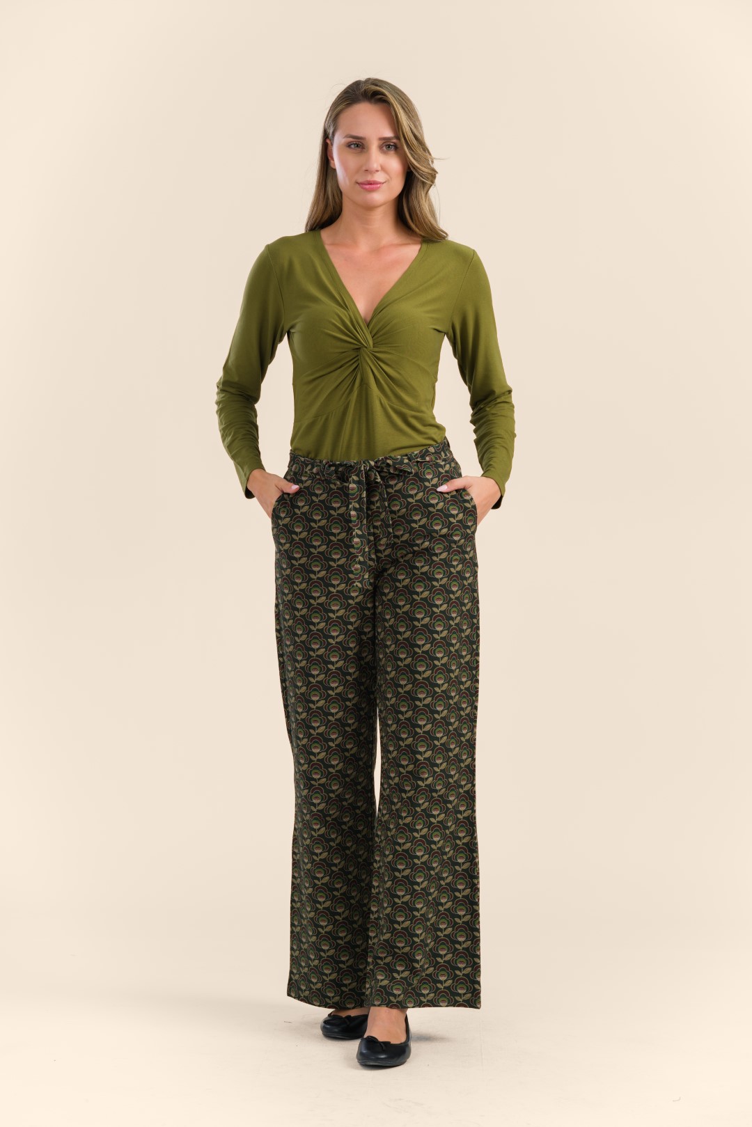 Sue Trousers LAWI24118 - Abstract Flower Green - Front (Groot) Model draagt groen jasje van velours en top en broek in bruine retroprint uit de winter 24 collectie van LaLamour